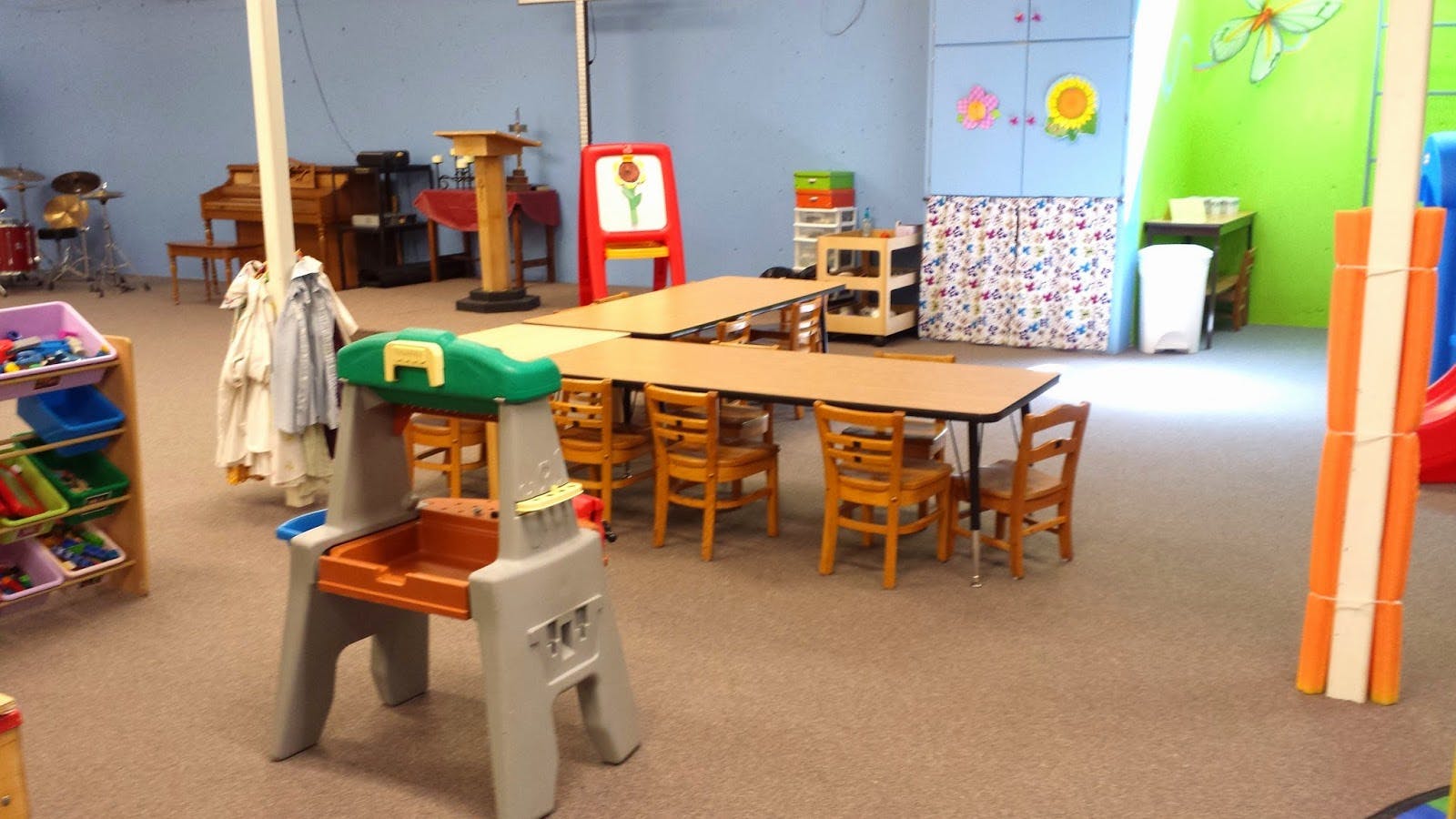 Children's play area with tables, chairs, and toys
