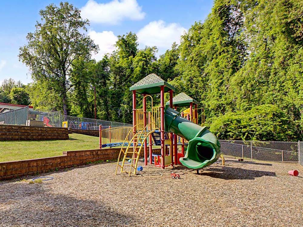Playground with green and yellow play structure and slide