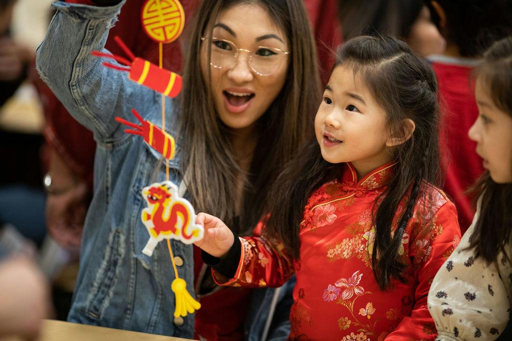 Person and child holding up a decorative string of ornaments
