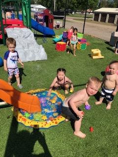 Children playing with water and toys on a playground
