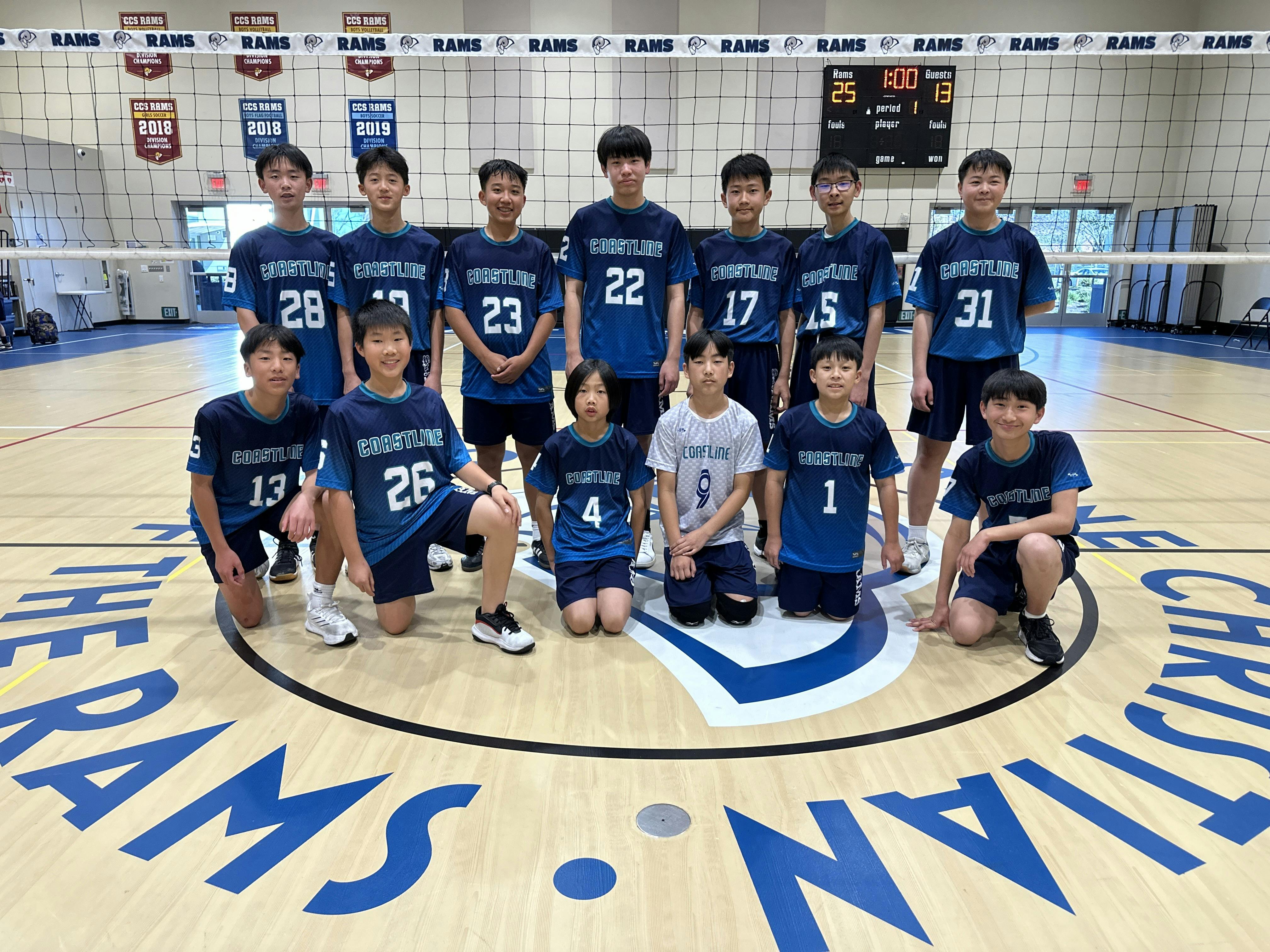 Group of teens and children in volleyball uniforms on a court