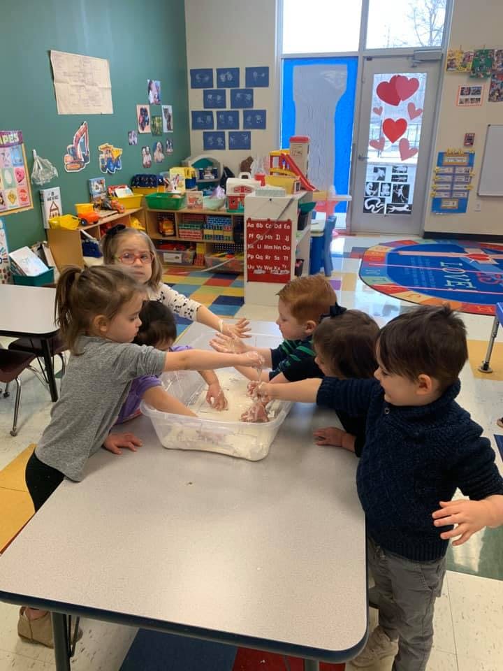 Children playing with a sensory bin in a classroom