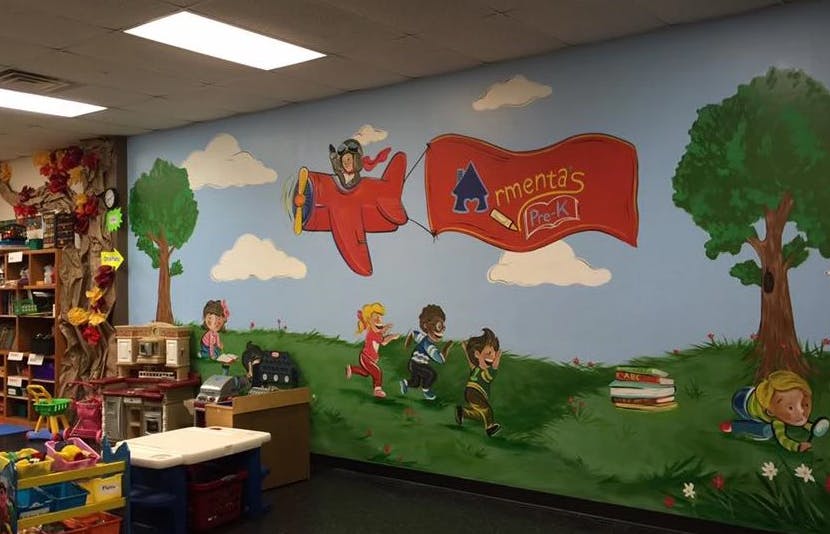 Mural of children playing on a hill with a plane flying a banner that says "Americas"
