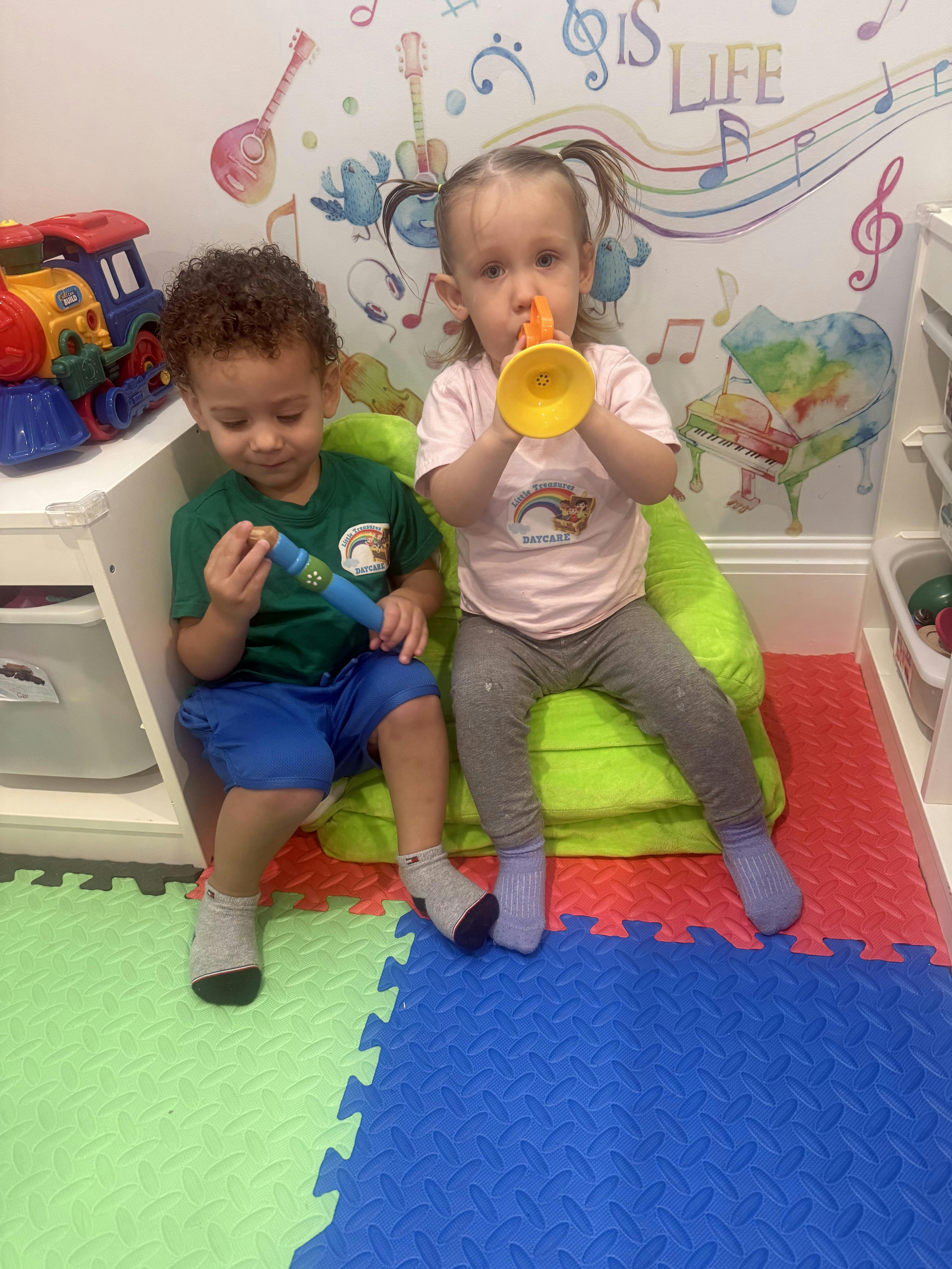 Two children playing with toy musical instruments