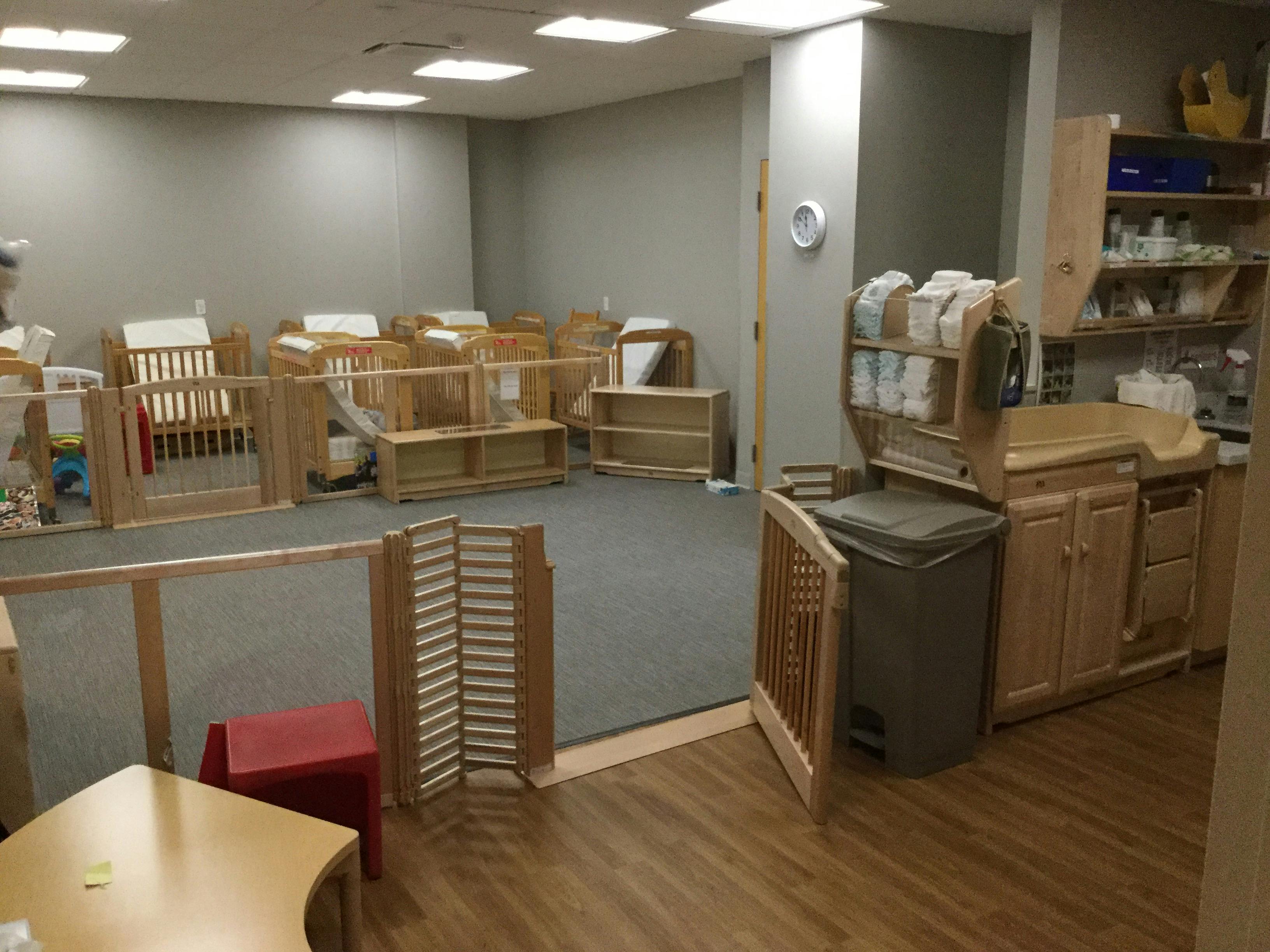 Room with multiple cribs and a changing station