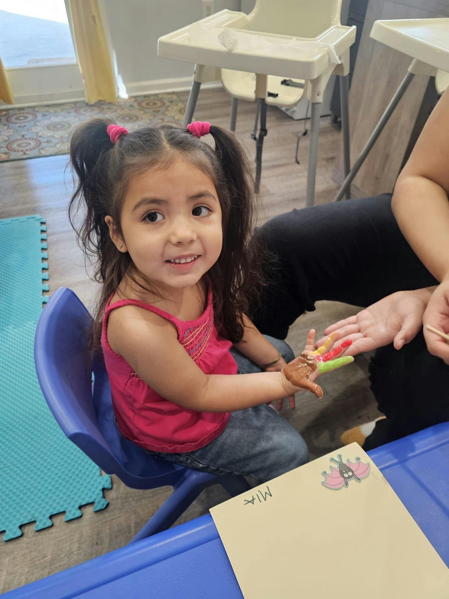 Child smiling with paint on hands