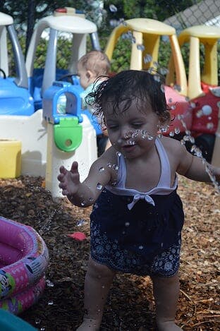 Child playing with water outdoors