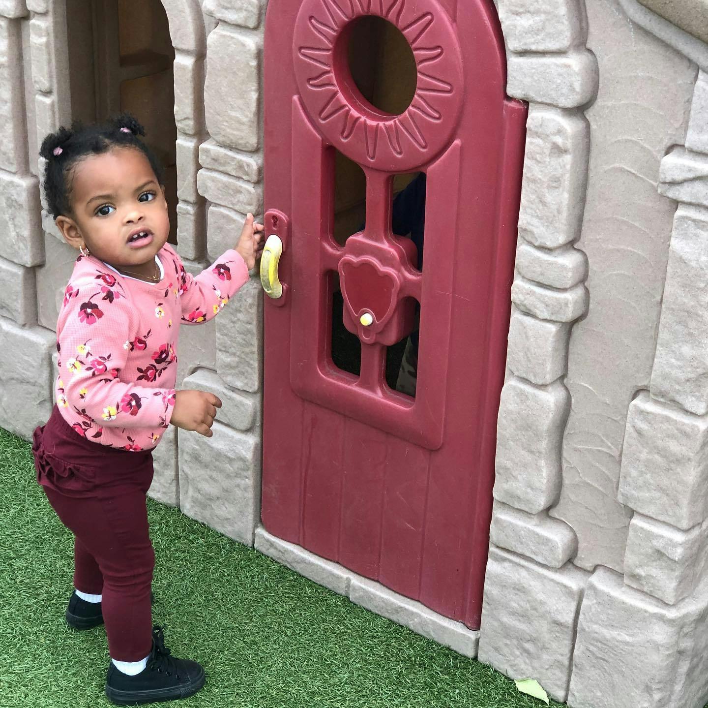 Child opening a playhouse door