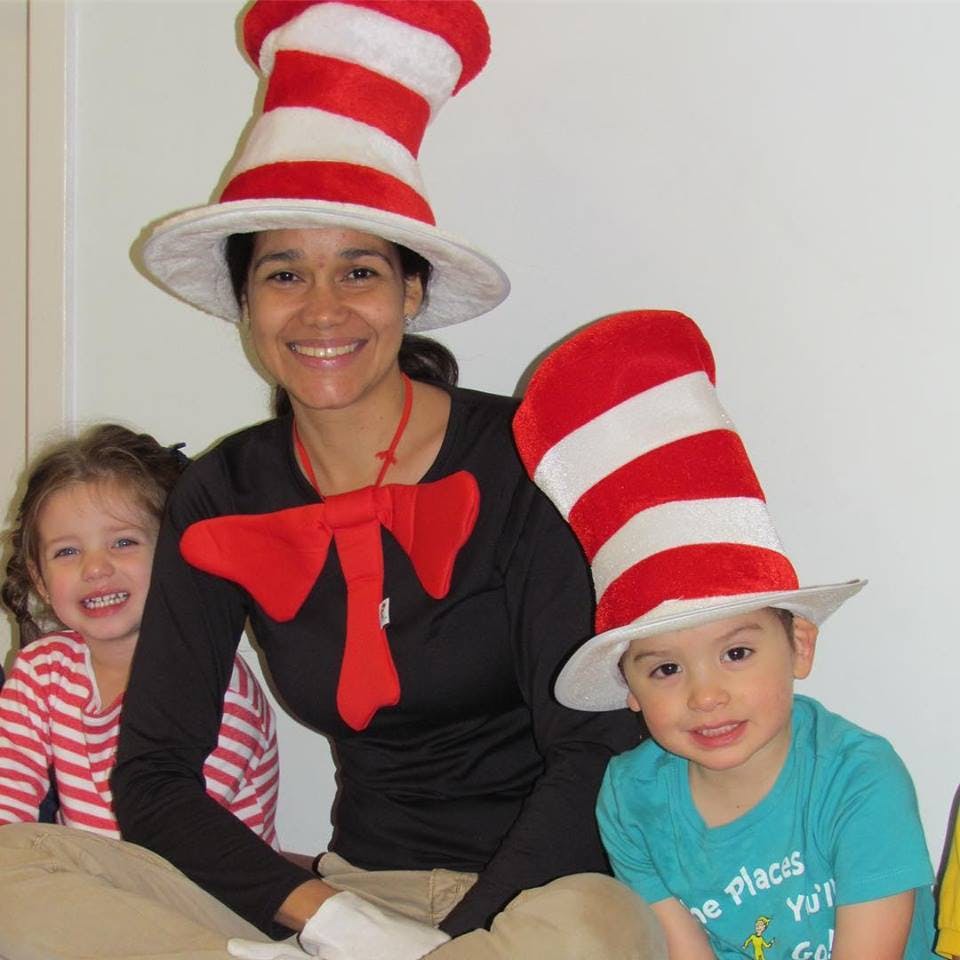 Person and two children wearing red and white striped hats