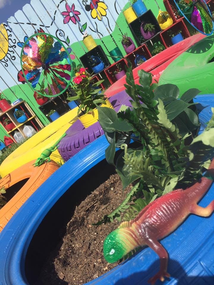 Colorful painted tires and a lizard toy in a garden