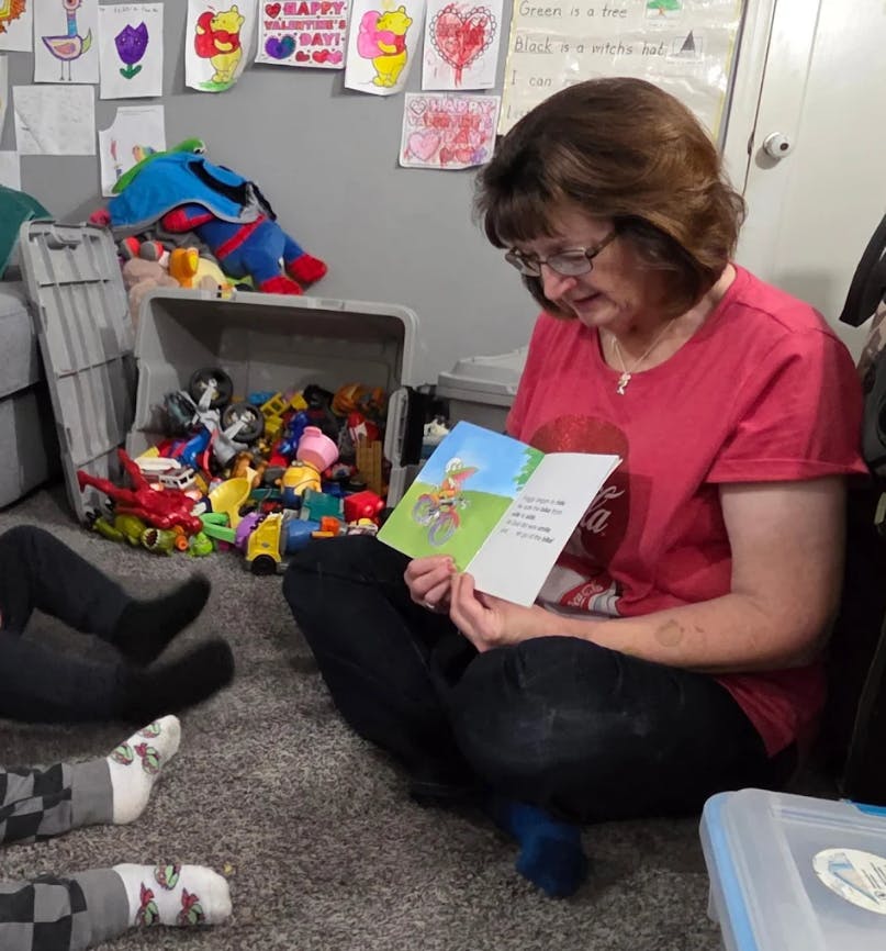 Person reading a children's book to a child
