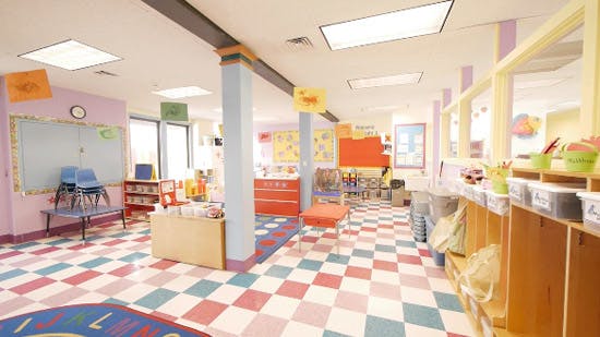 Empty classroom with colorful checkered floor and small furniture