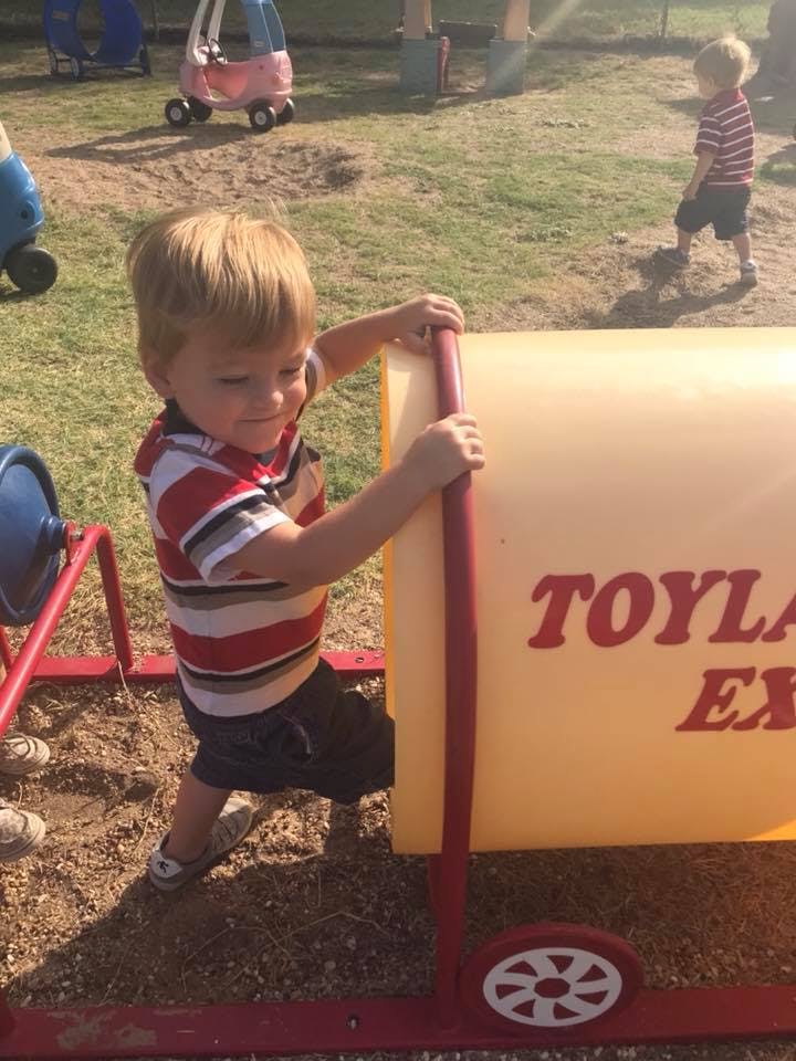 Child playing on a yellow toy with red toy