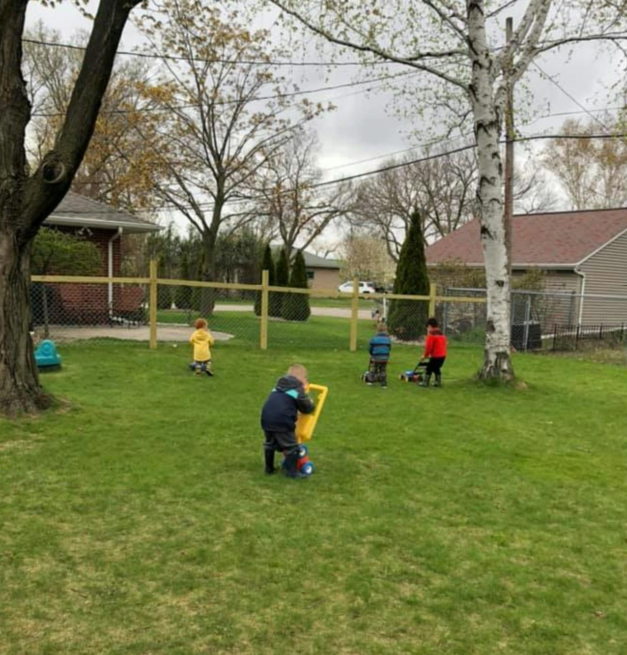 Children playing with toys in a grassy yard