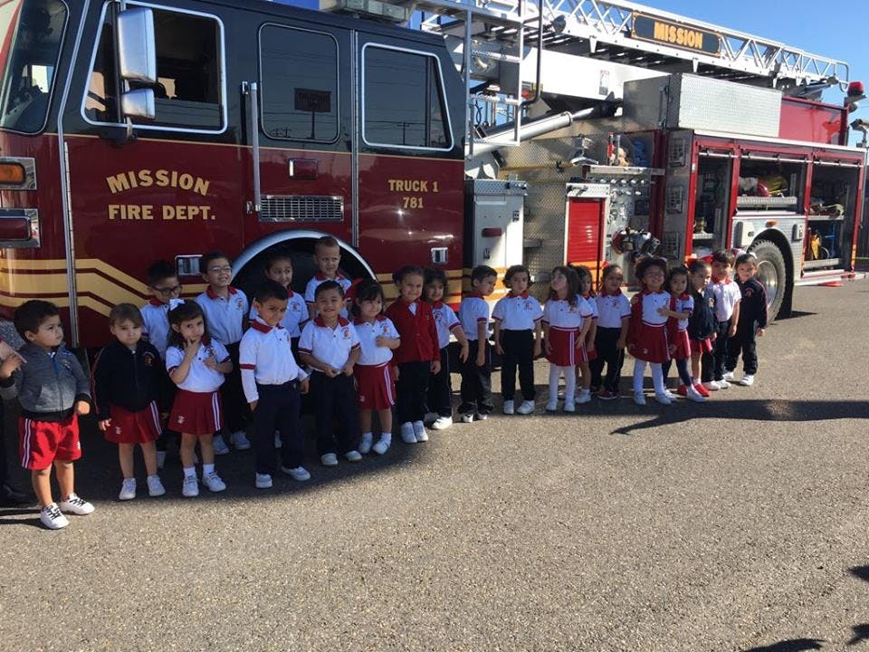 Children standing in front of a fire truck