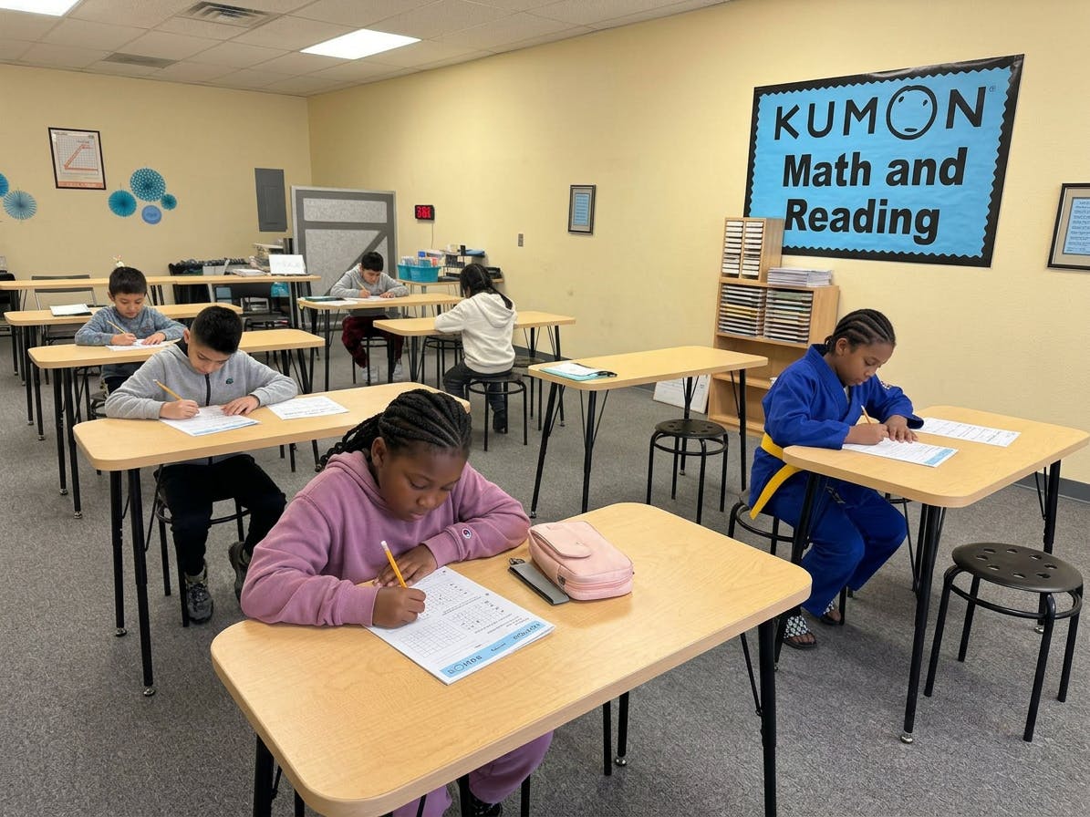 Children working on papers at individual desks in a classroom