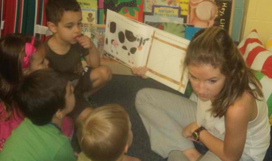 Person reading a book to children