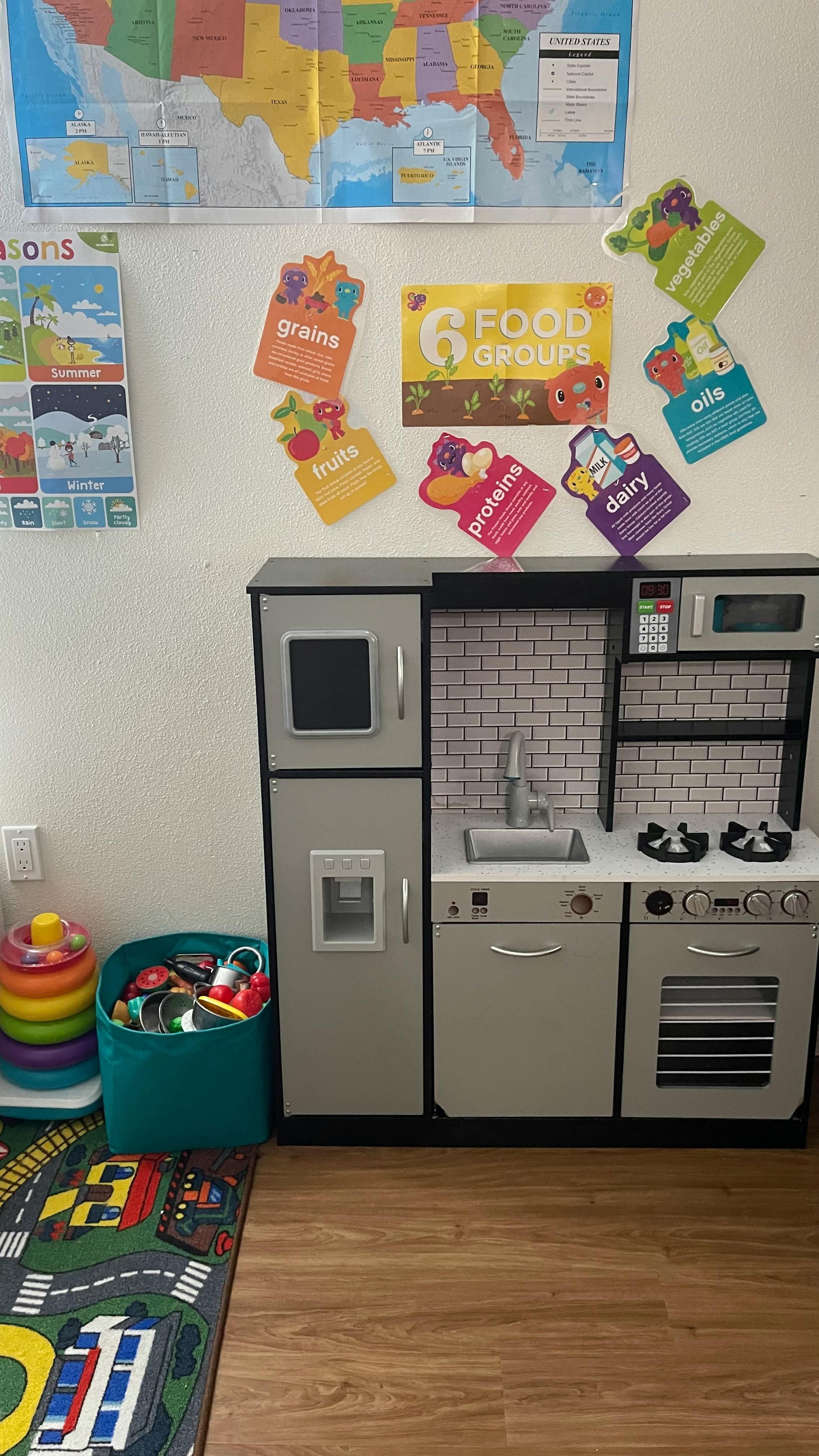 Play kitchen with a refrigerator, sink, and stove