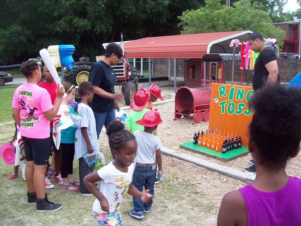 People and children gathered around a Ring Toss game
