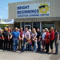 Group of people at a ribbon cutting ceremony in front of a building