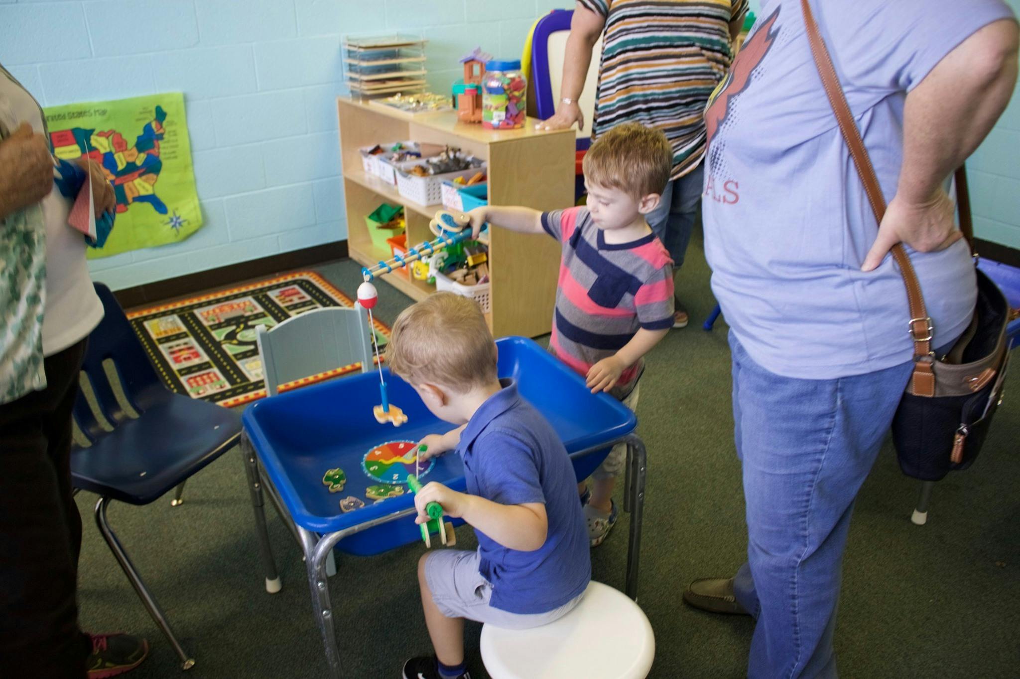 Two children playing with a water table in a classroom