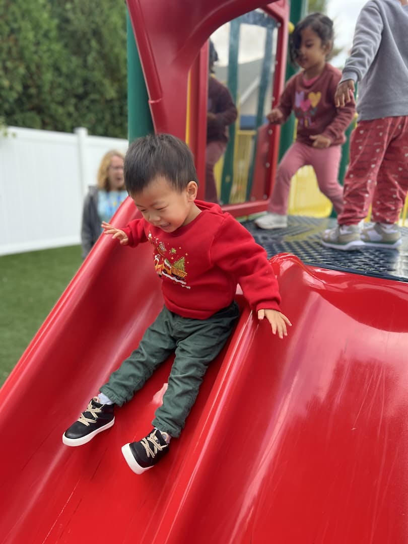 Child on a red slide at a playground