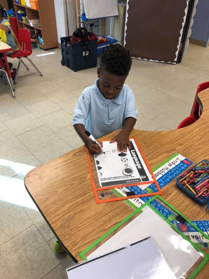 Child writing on a worksheet at a desk