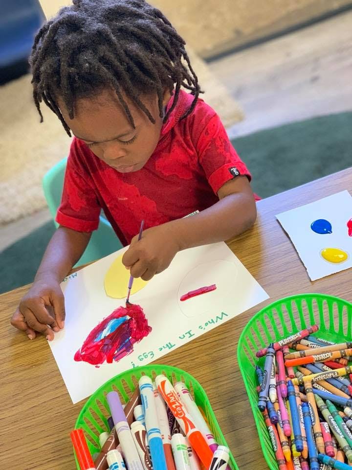 Child painting on paper at a table