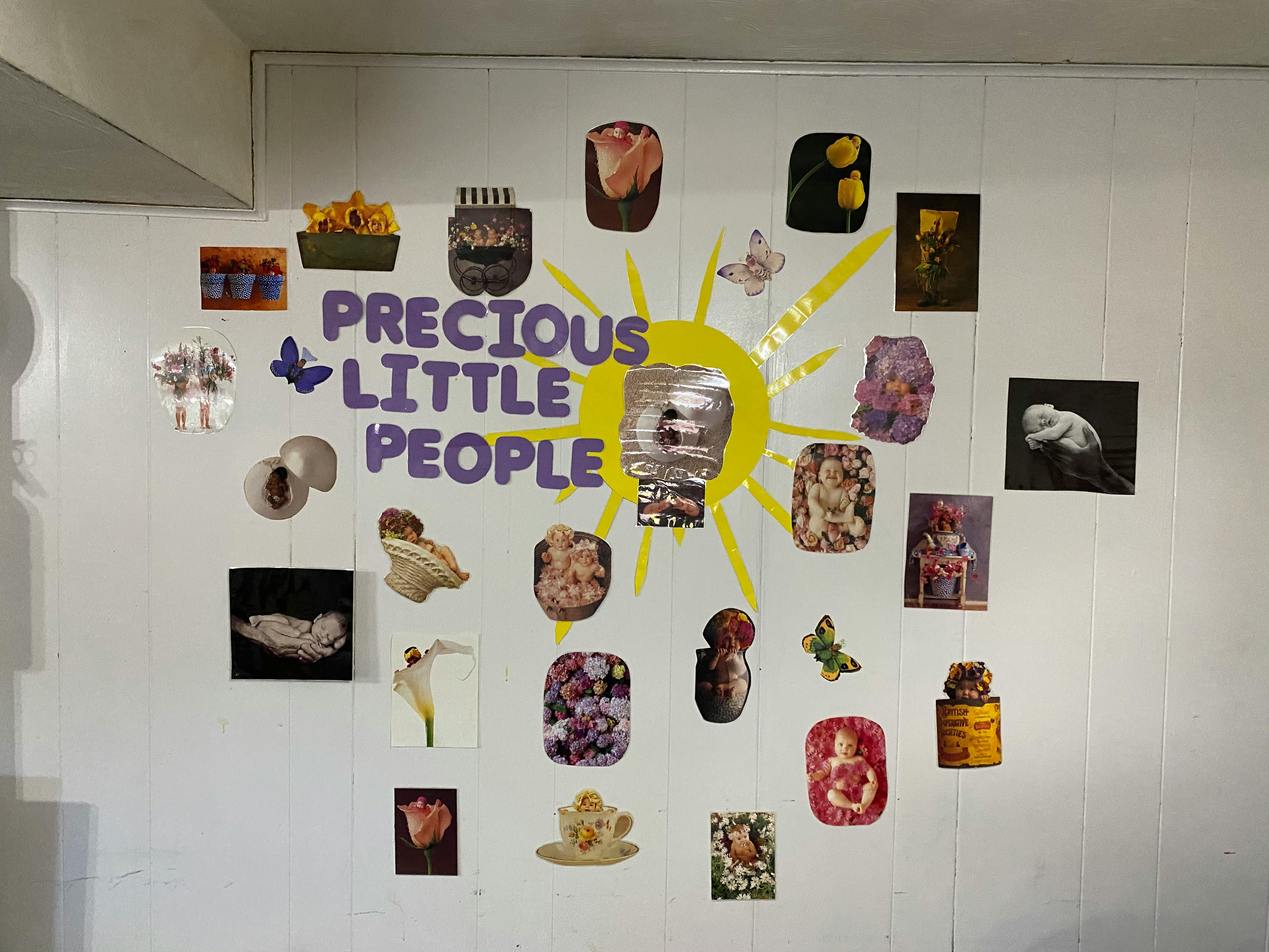Wall display with text "PRECIOUS LITTLE PEOPLE" and various small images