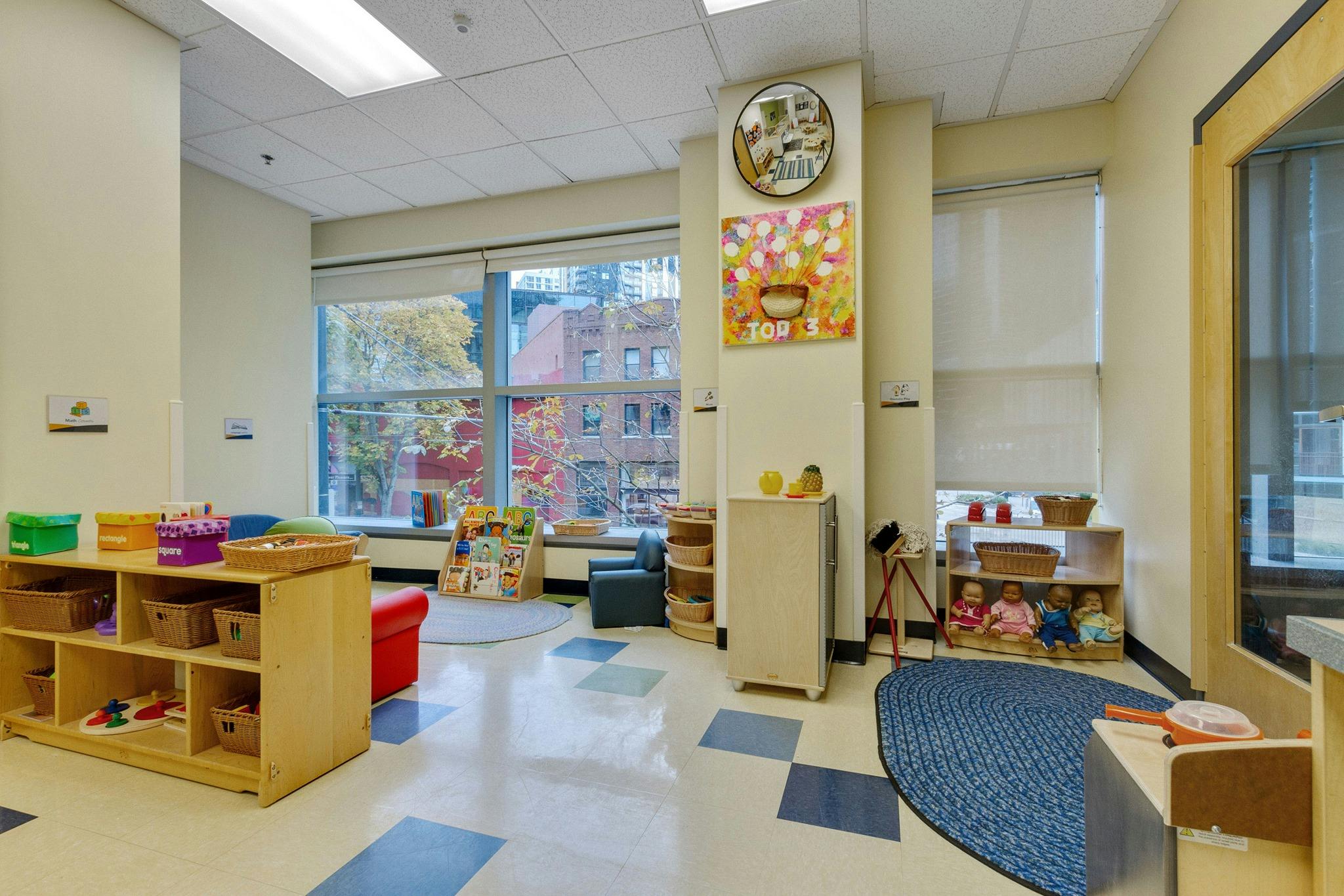 Empty classroom with shelves, toys, and large windows
