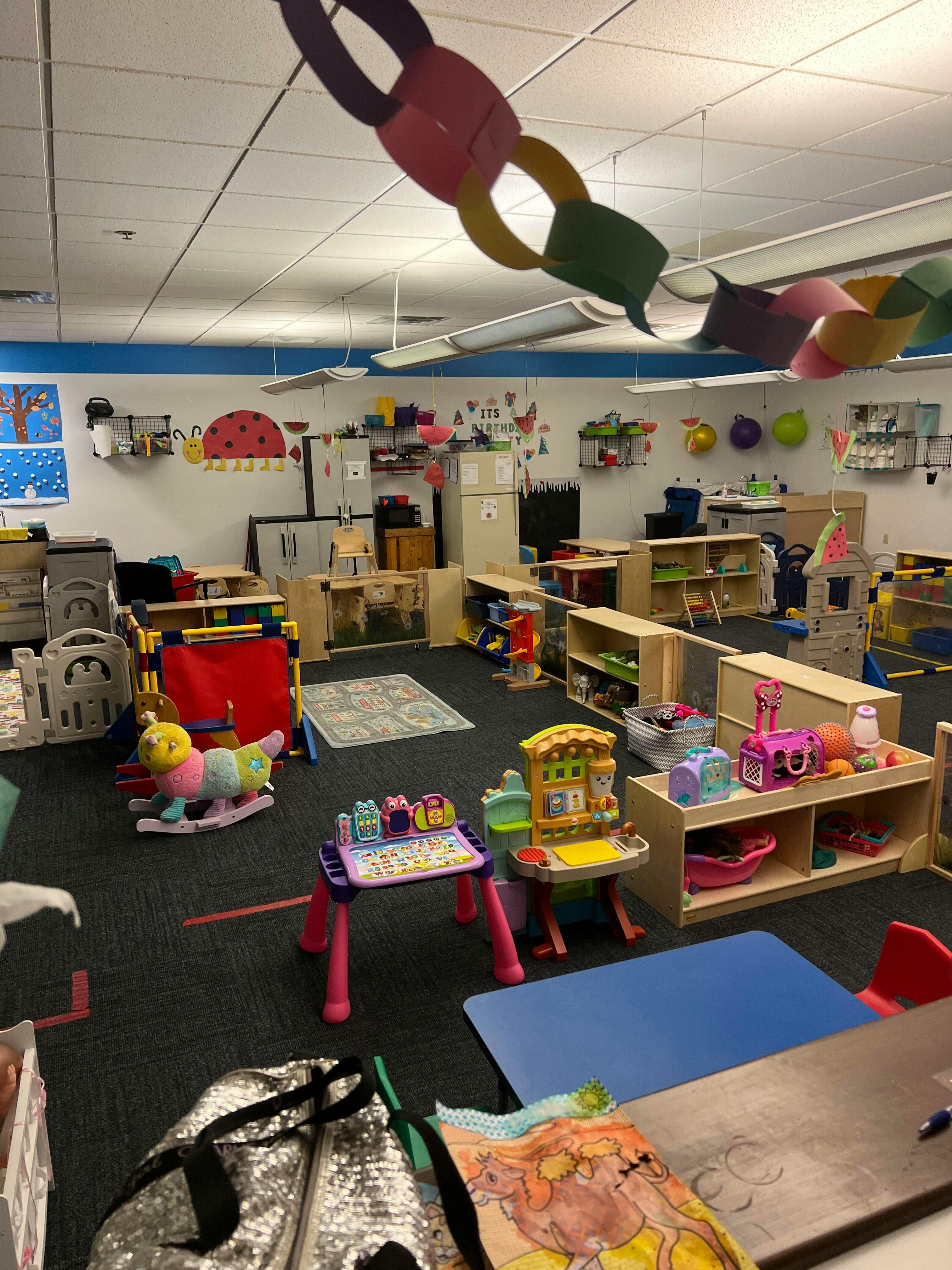 Playroom with various toys, small tables, and shelves