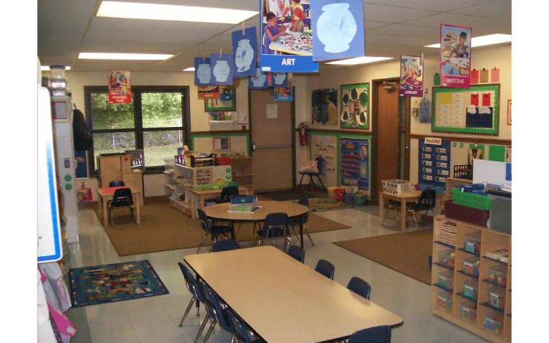 A colorful empty classroom with small tables and chairs