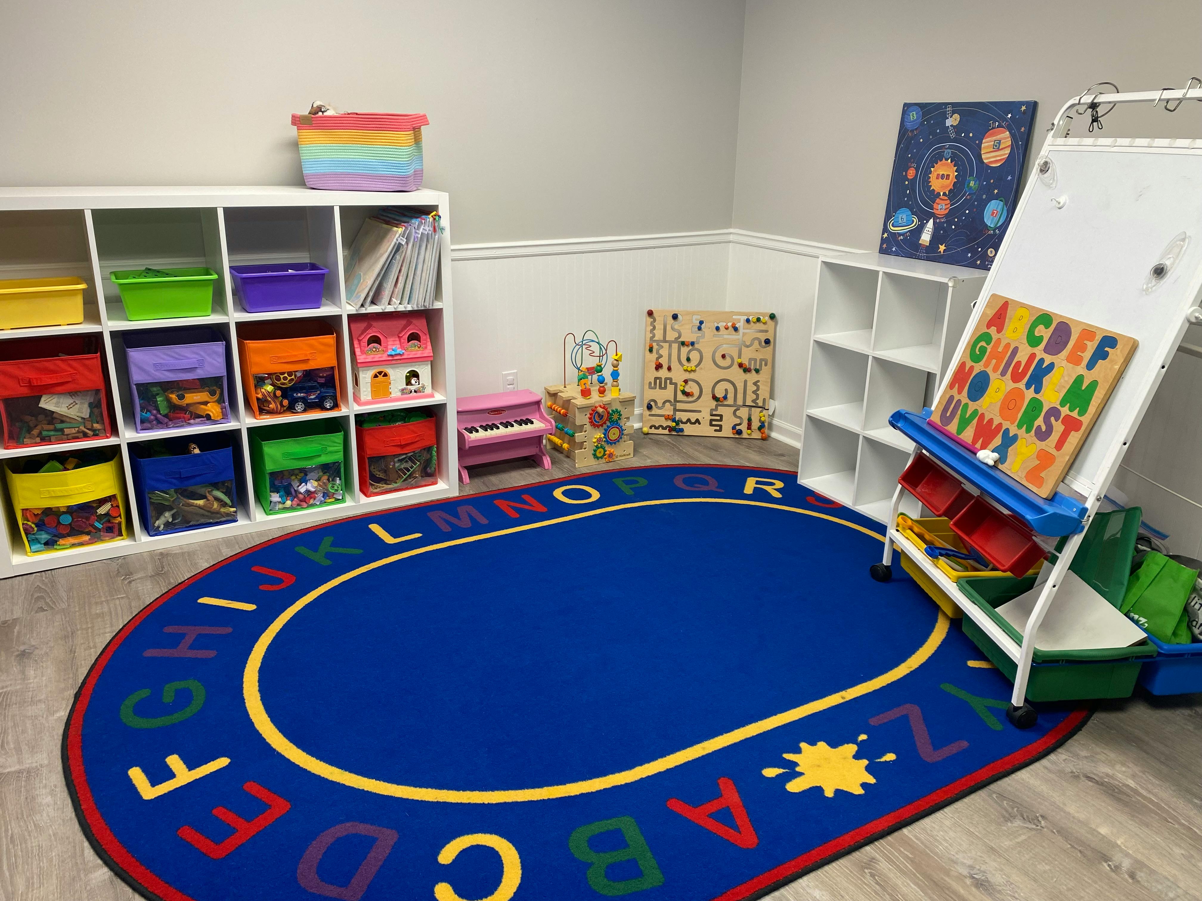 Playroom with alphabet rug, storage shelves, and easel