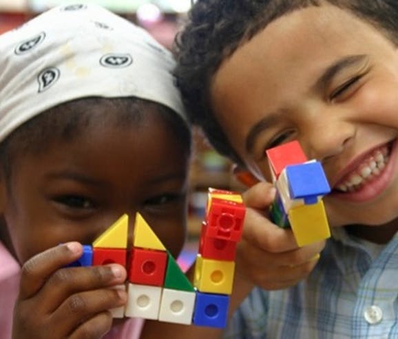 Two children playing with colorful building blocks