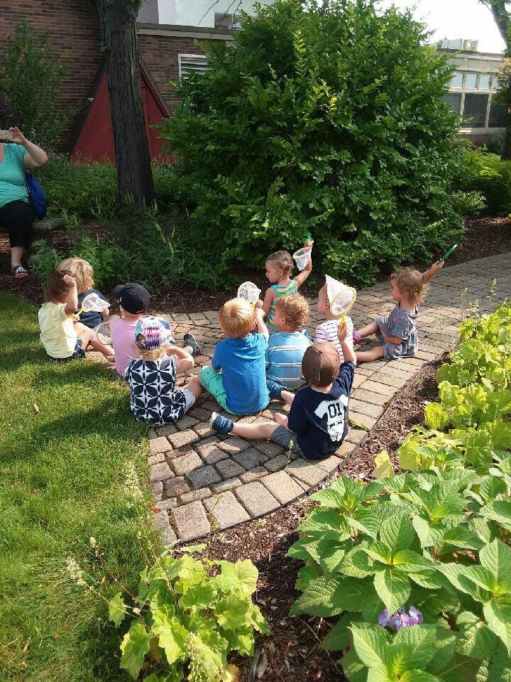 Children sitting on a brick path outdoors