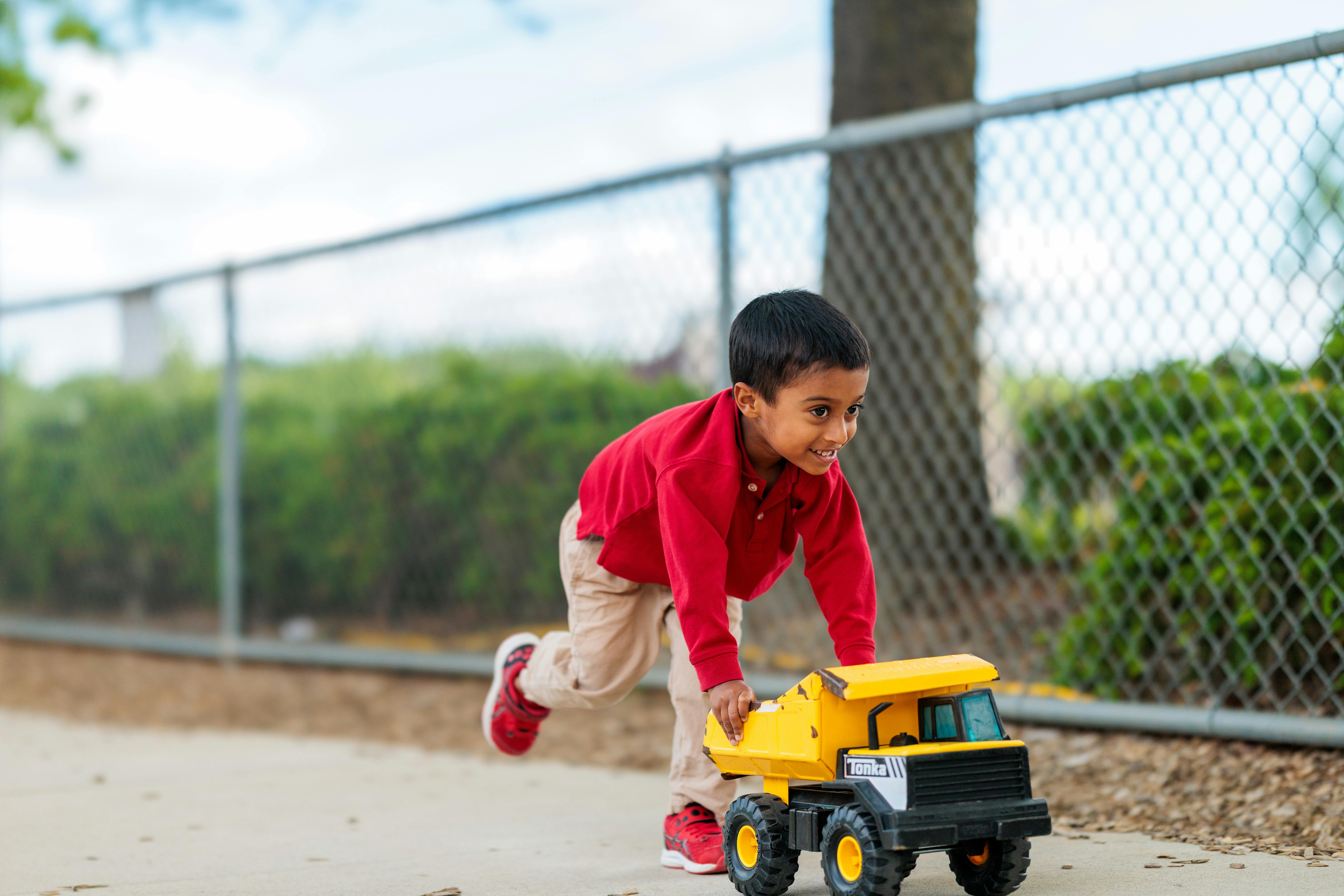 Child pushing a toy dump truck