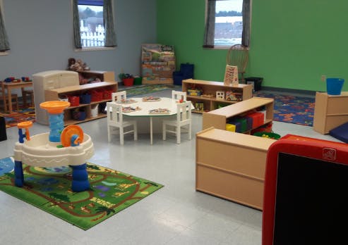 Playroom with small tables, chairs, and toys