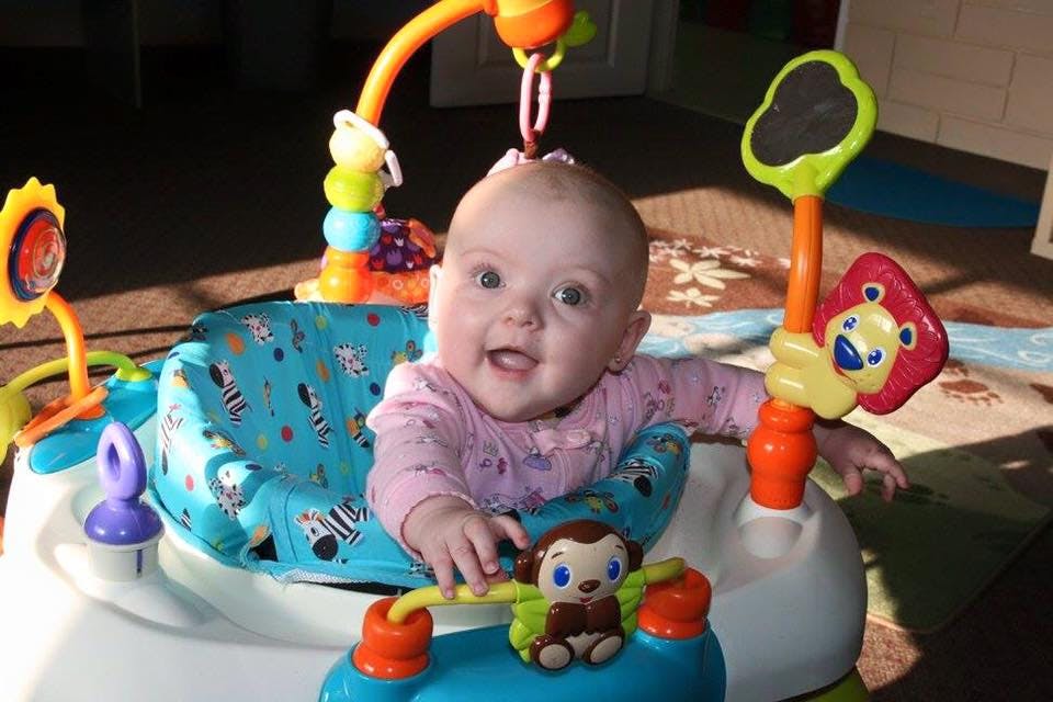 Child in a baby activity center with toys