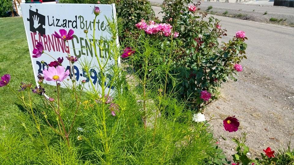 Sign for Lizard Butte Learning Center surrounded by flowers