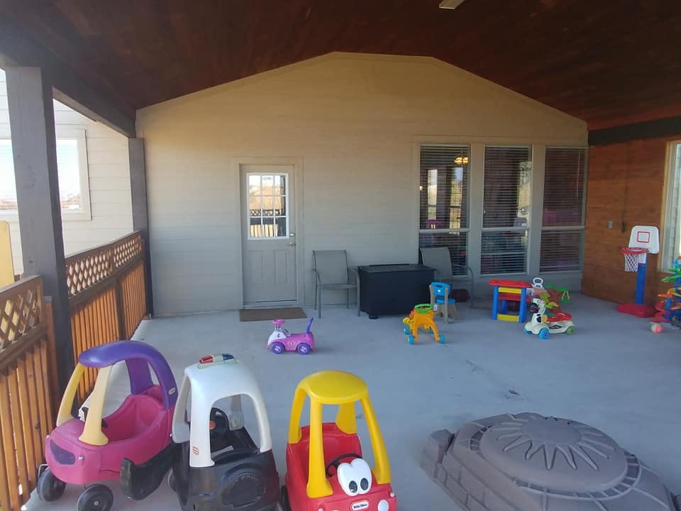 Covered patio with children's ride-on toys and play equipment