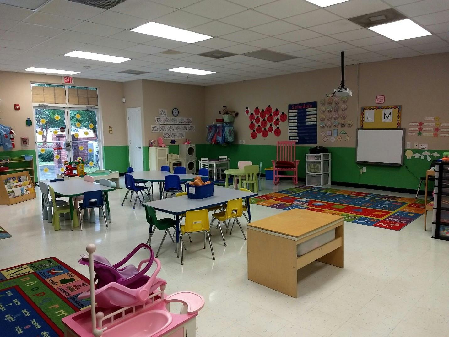 Classroom with small tables, chairs, and learning decorations