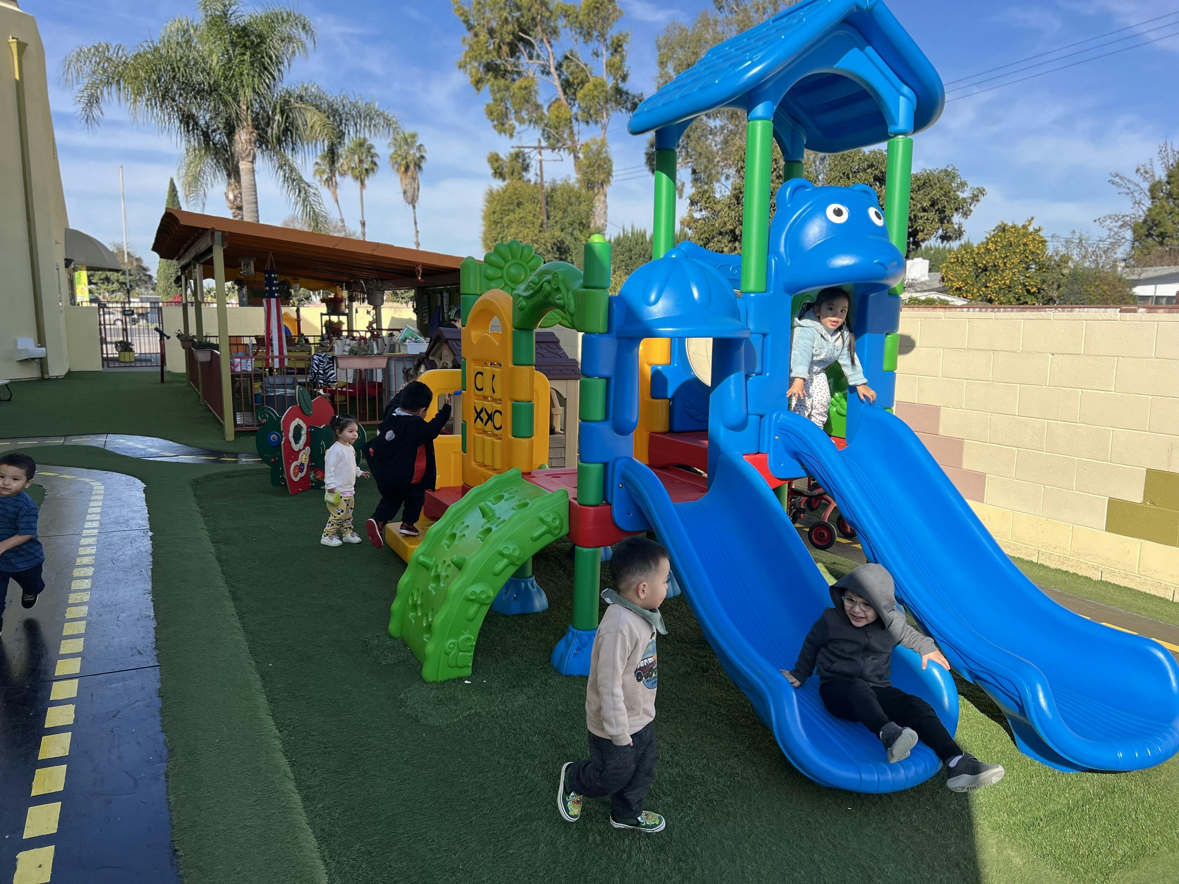 Children playing on a colorful playground structure with slides