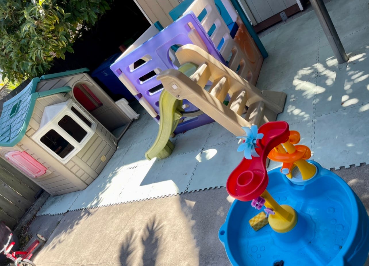 Playhouse, slide, and water table on a padded surface