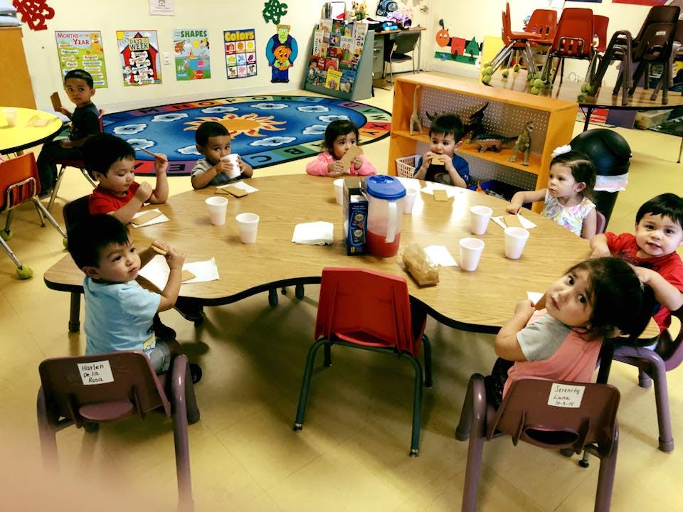 Children sitting at a table in a classroom