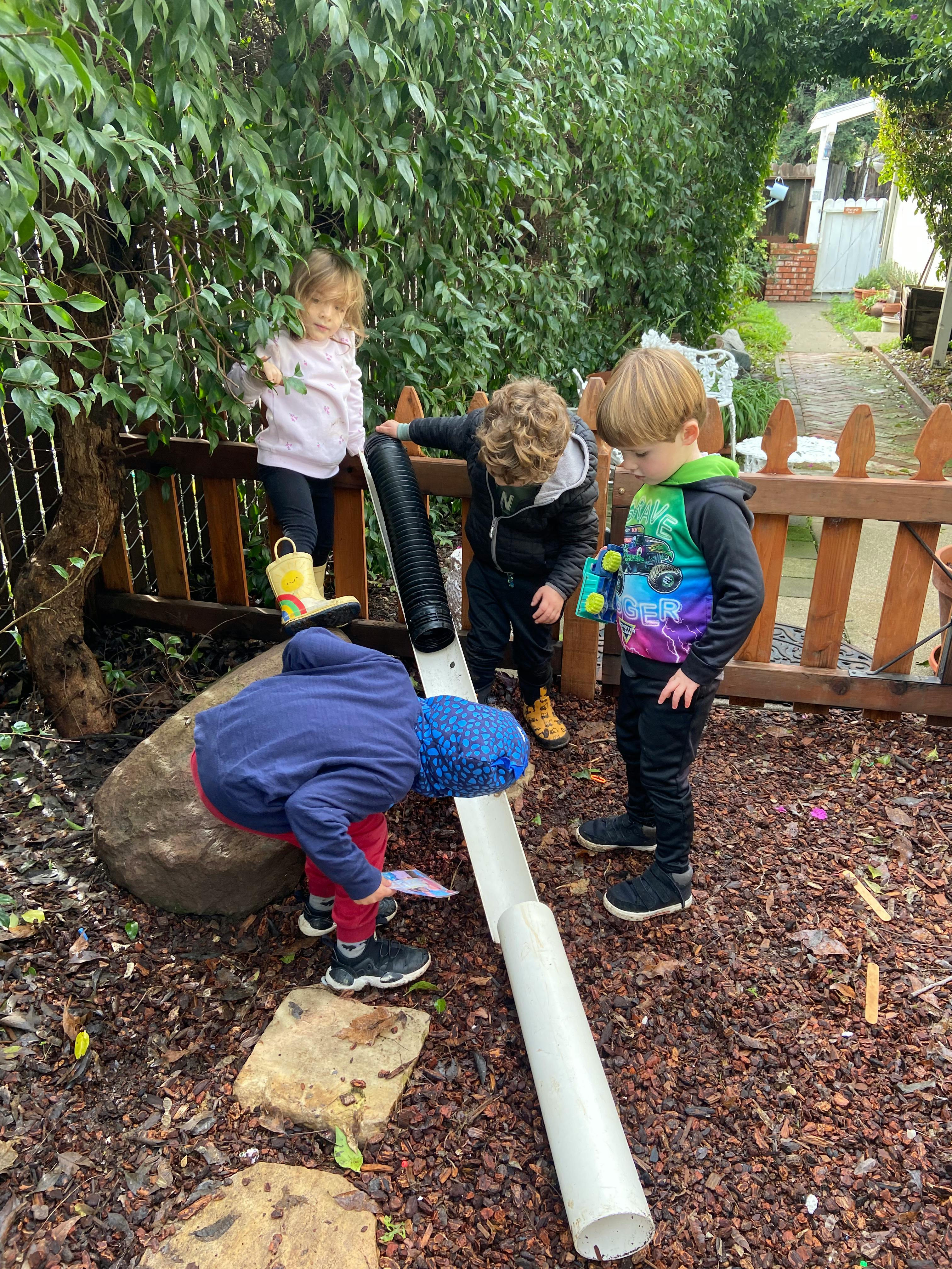 Children playing with pipes outdoors