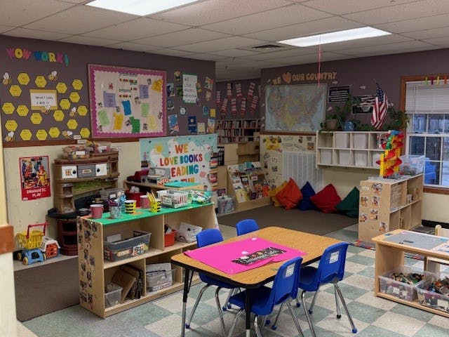 An empty classroom with various learning stations and colorful decor