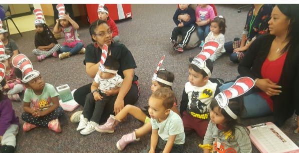 People and children wearing striped hats sitting on the floor