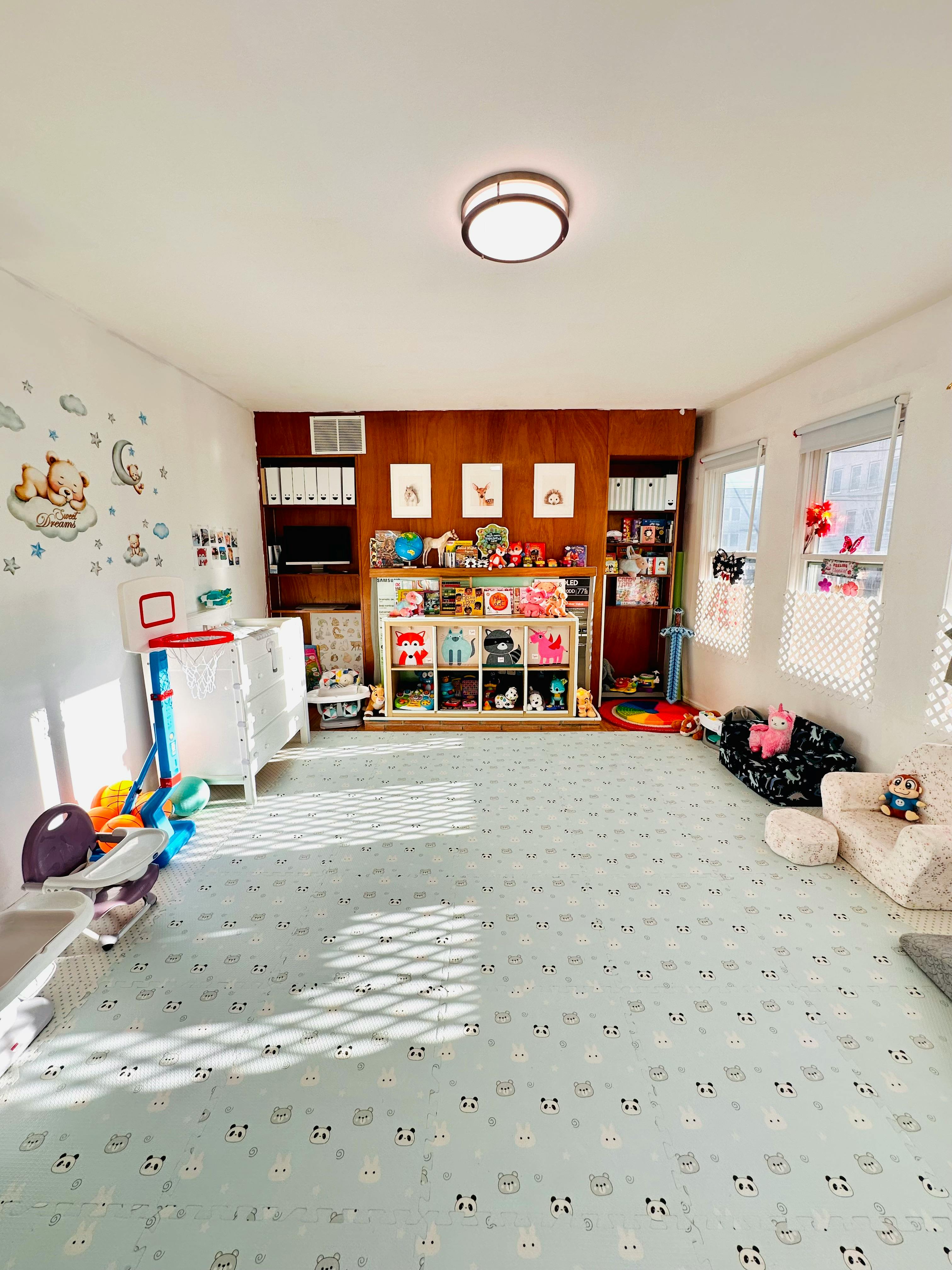 Playroom with toys organized on shelves and mats on the floor