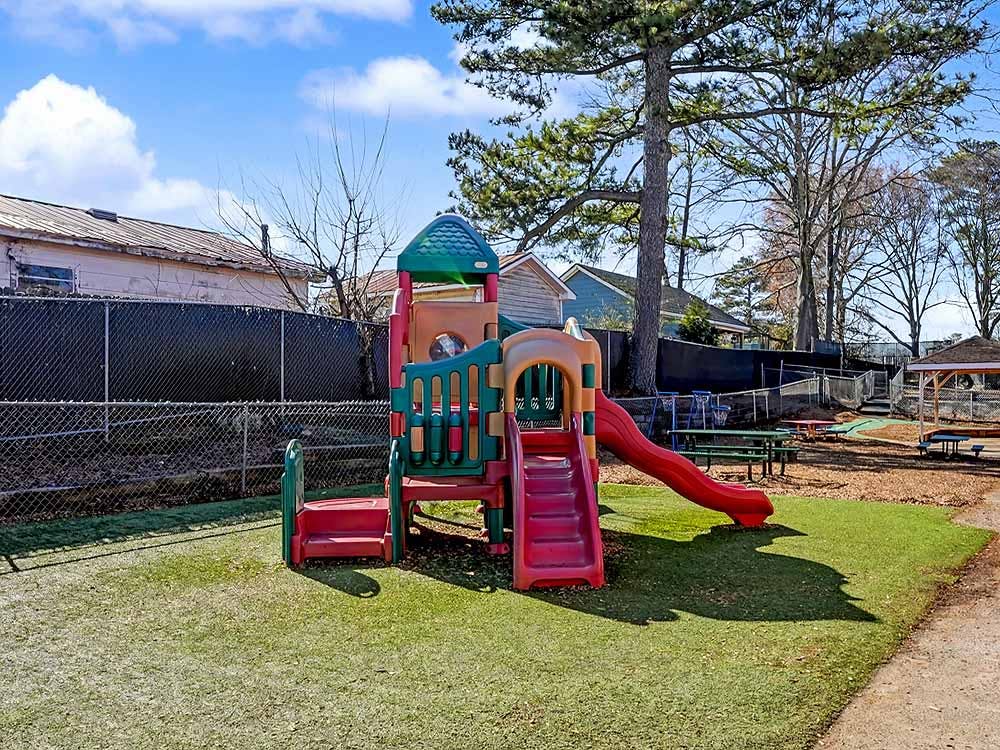 Colorful playground structure with slides on artificial turf