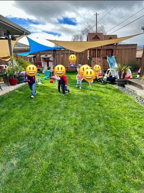Children playing in a grassy backyard with shade sails